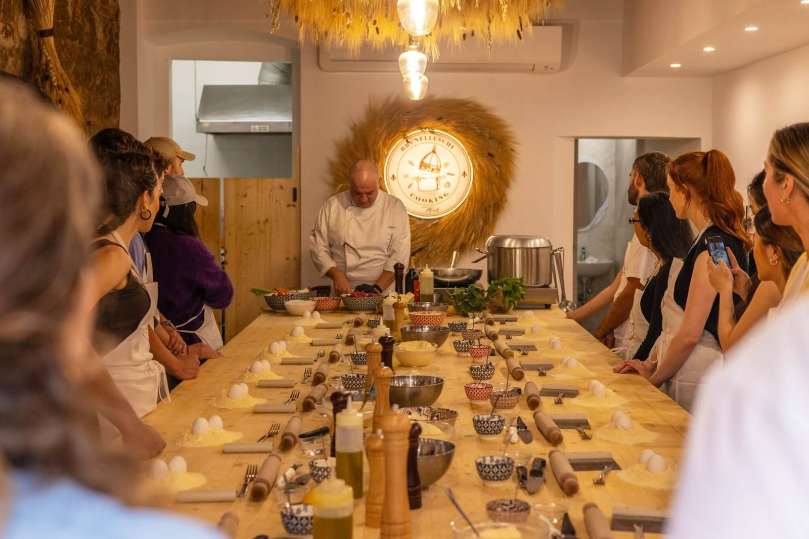 Chef preparing ingredients with class participants at the Cooking Art Brunelleschi kitchen